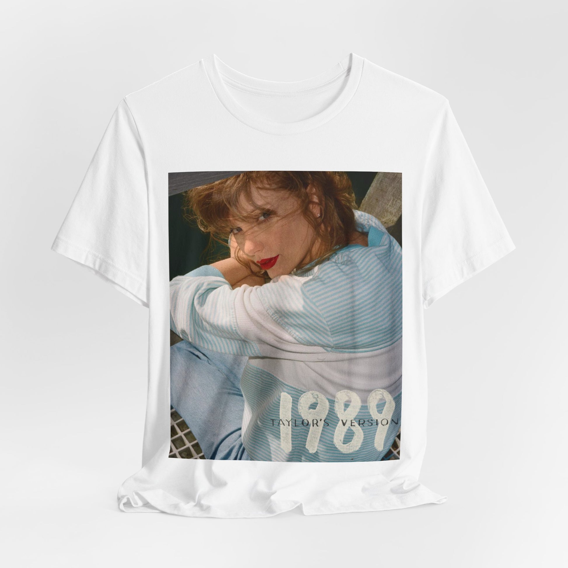 A black graphic t-shirt featuring a 1989 aesthetic graphic of Taylor Swift.