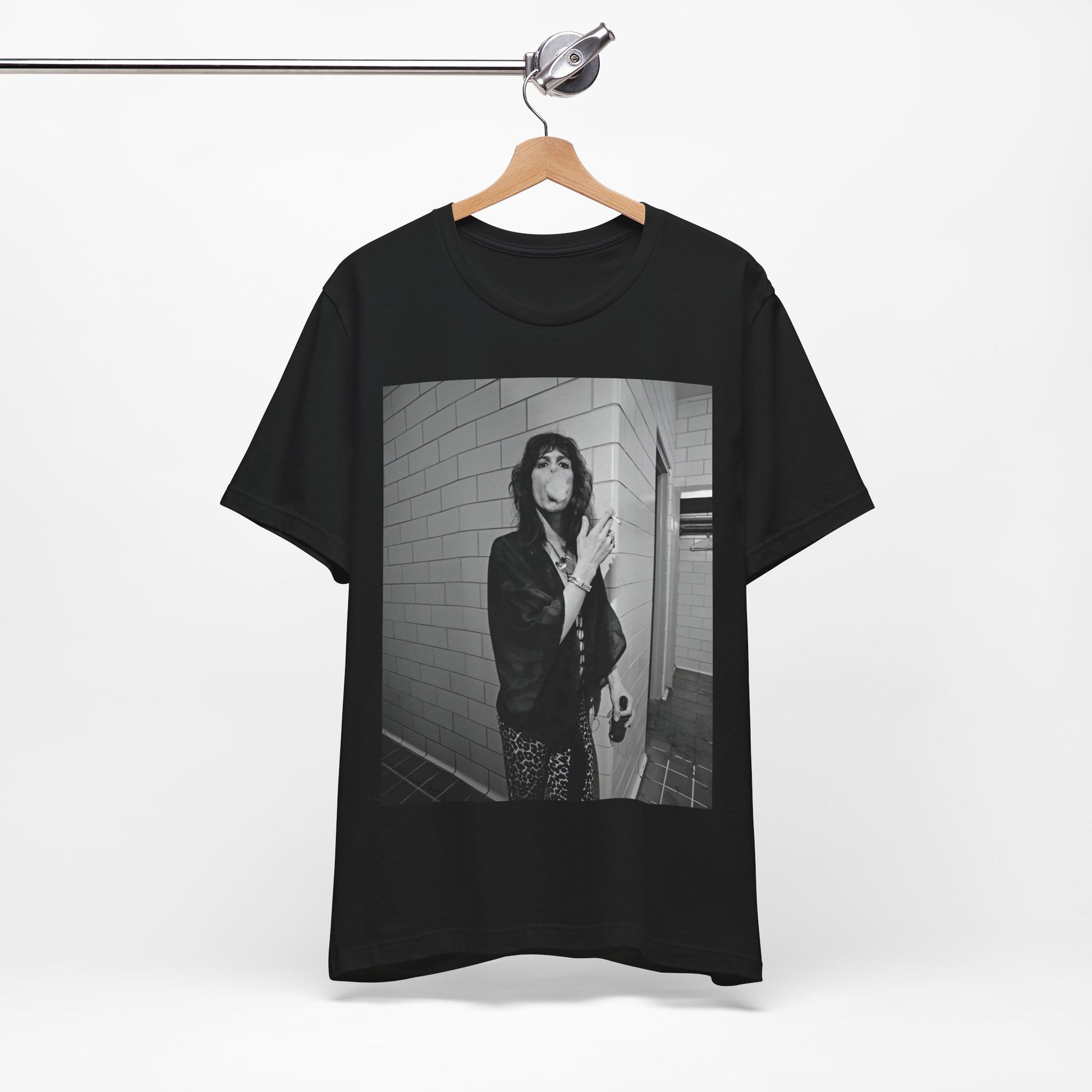 A black graphic t-shirt featuring a retro 70s photo of Aerosmith band members in a backstage setting, showing a candid moment.