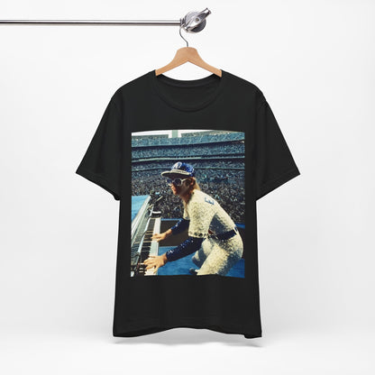 A black graphic t-shirt featuring a photo of Elton John from his 1975 Dodgers Stadium concert.