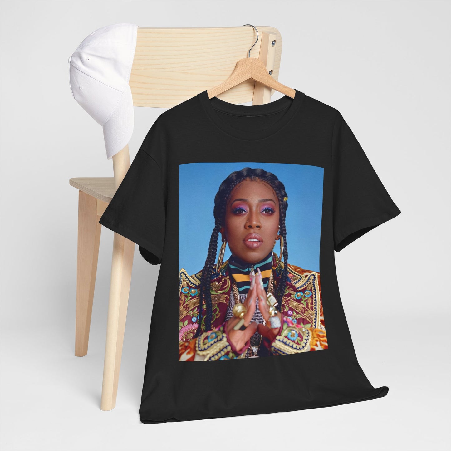 A black graphic t-shirt featuring a graphic of Missy Elliott with a cool, futuristic rap fashion aesthetic.