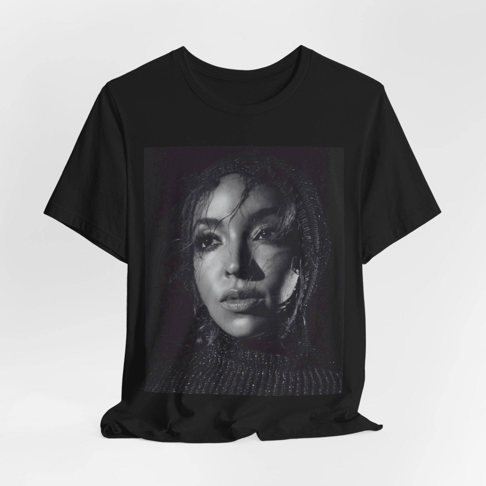 A black graphic t-shirt featuring a black and white portrait photo of Tinashe.