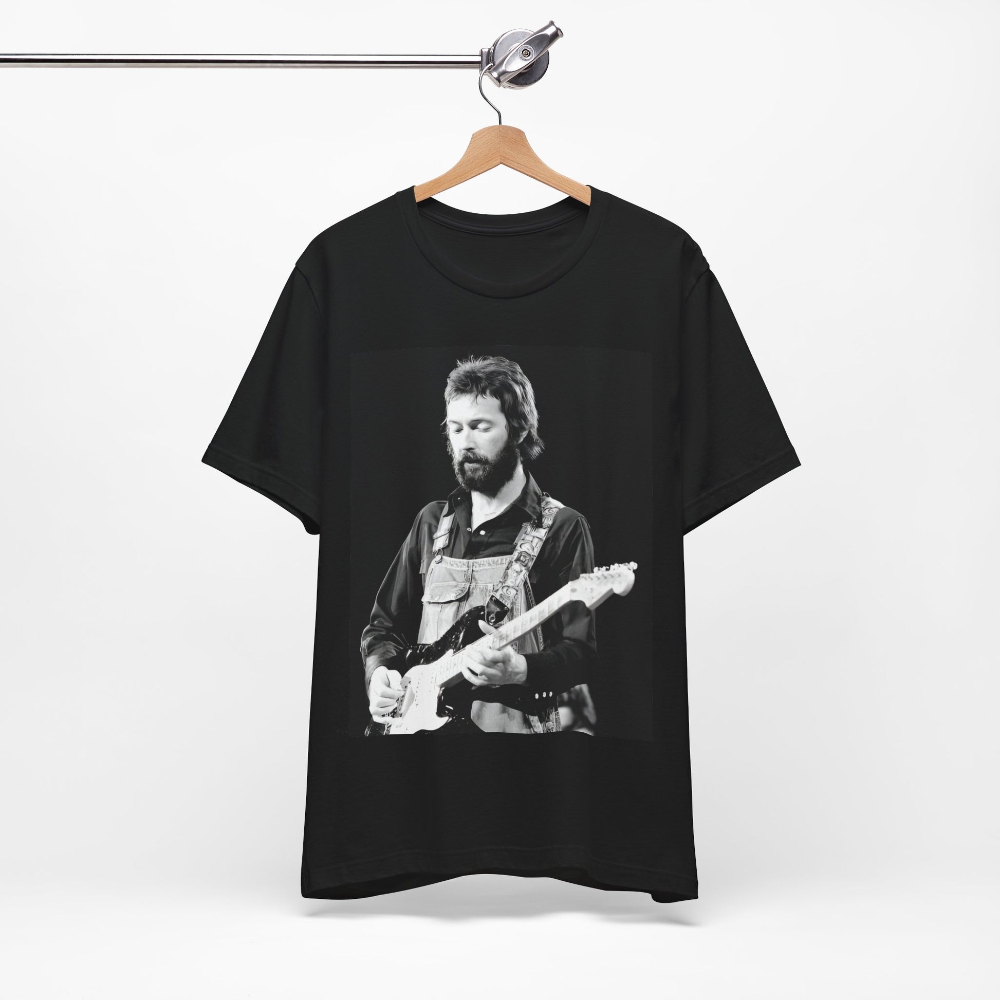 A black graphic t-shirt featuring a graphic or photo of Eric Clapton performing live on stage with his guitar.