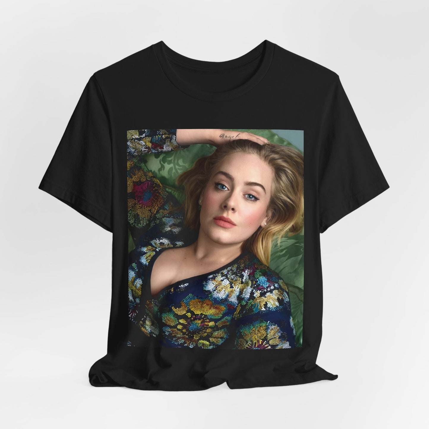 A black graphic t-shirt featuring a photo of Adele, possibly with floral elements or a floral background, showing a serene or contemplative expression.