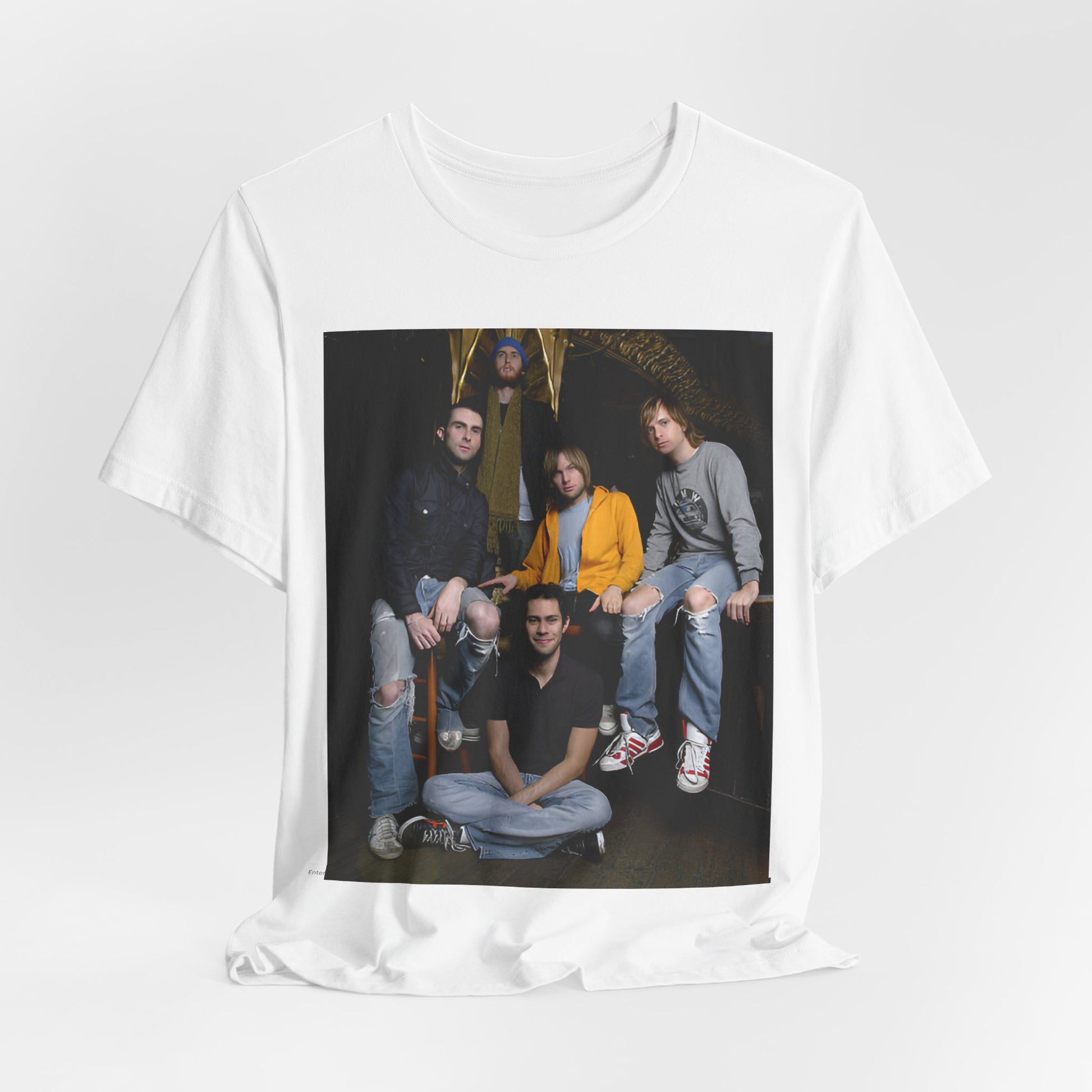 A high-energy, colorful photo of Maroon 5 performing live on stage at a concert, printed on a graphic t-shirt.