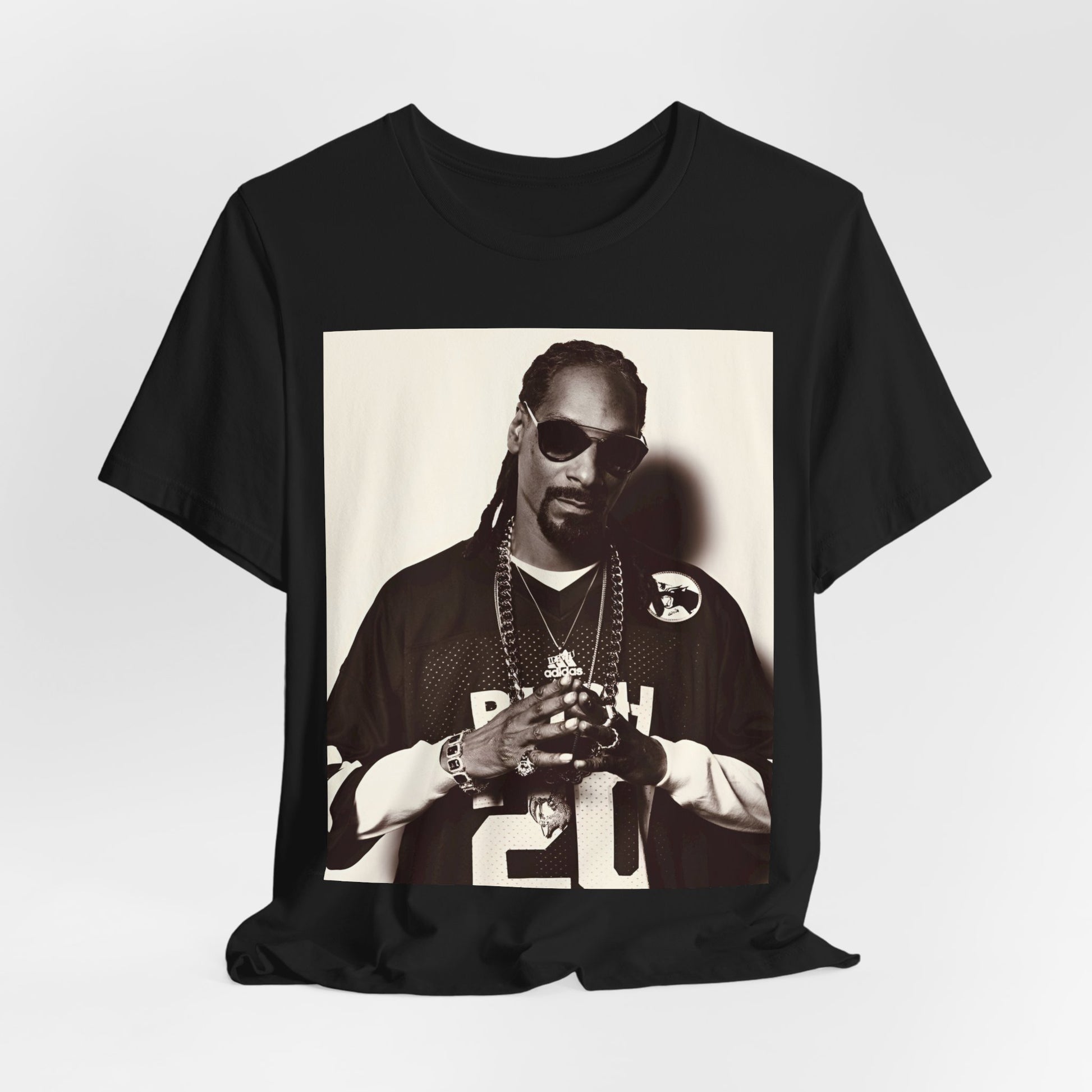 A black graphic t-shirt featuring a black and white, monochrome graphic or photo of Snoop Dogg in an OG style.