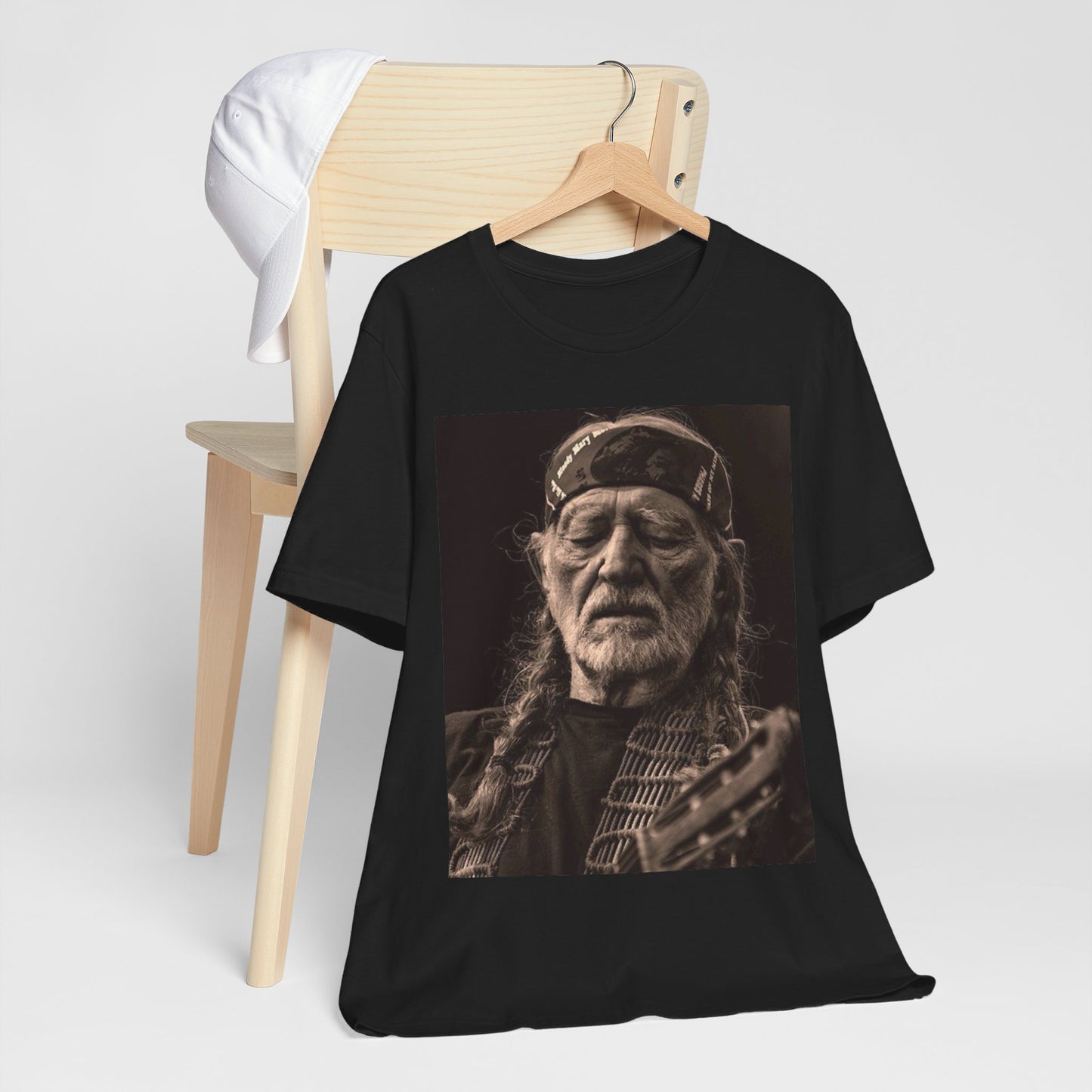 A black graphic t-shirt featuring a graphic of Willie Nelson with his iconic braids style.