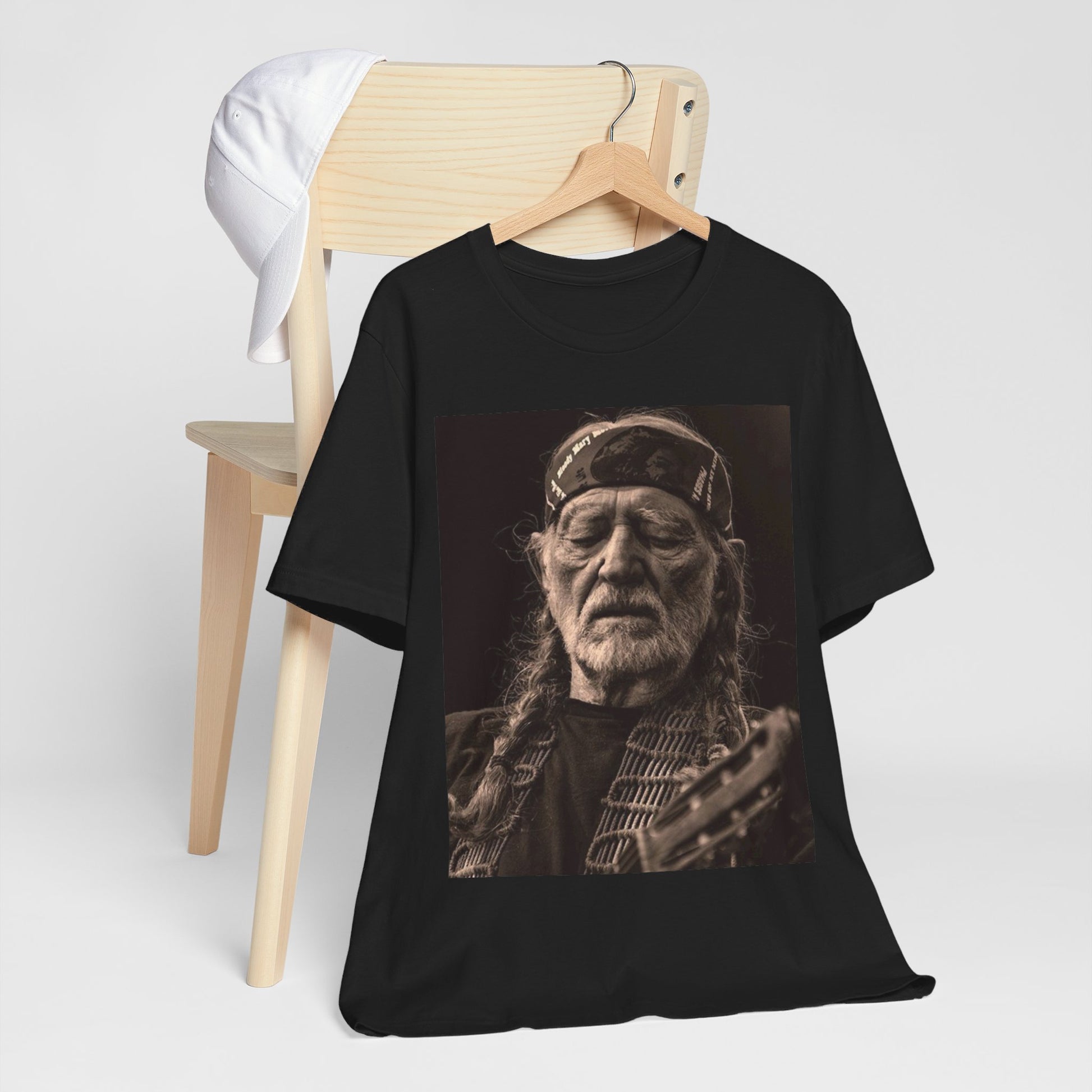 A black graphic t-shirt featuring a graphic of Willie Nelson with his iconic braids style.