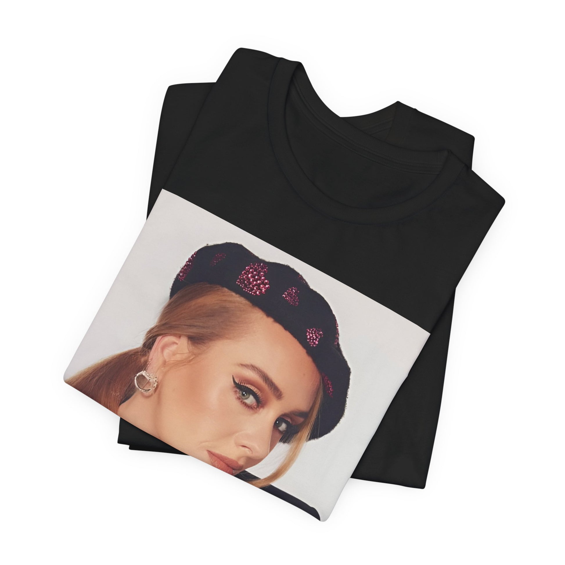 A black graphic t-shirt featuring a black and white photo of Adele wearing a heart-shaped beret, with a gentle or smiling expression.