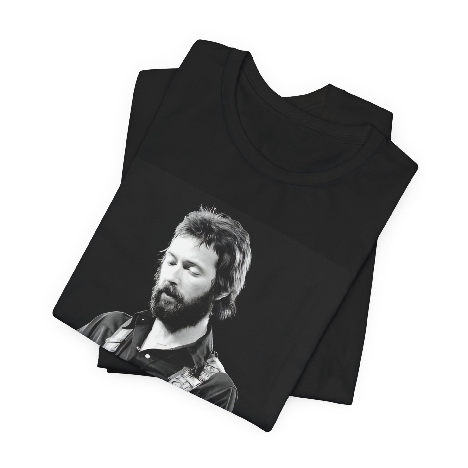 A black graphic t-shirt featuring a graphic or photo of Eric Clapton performing live on stage with his guitar.