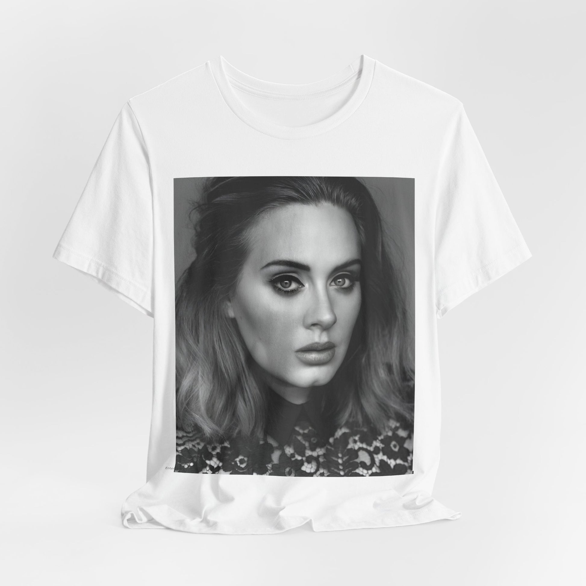 A black graphic t-shirt featuring a classic black and white, monochrome portrait of Adele, showing her with a serene or thoughtful expression.