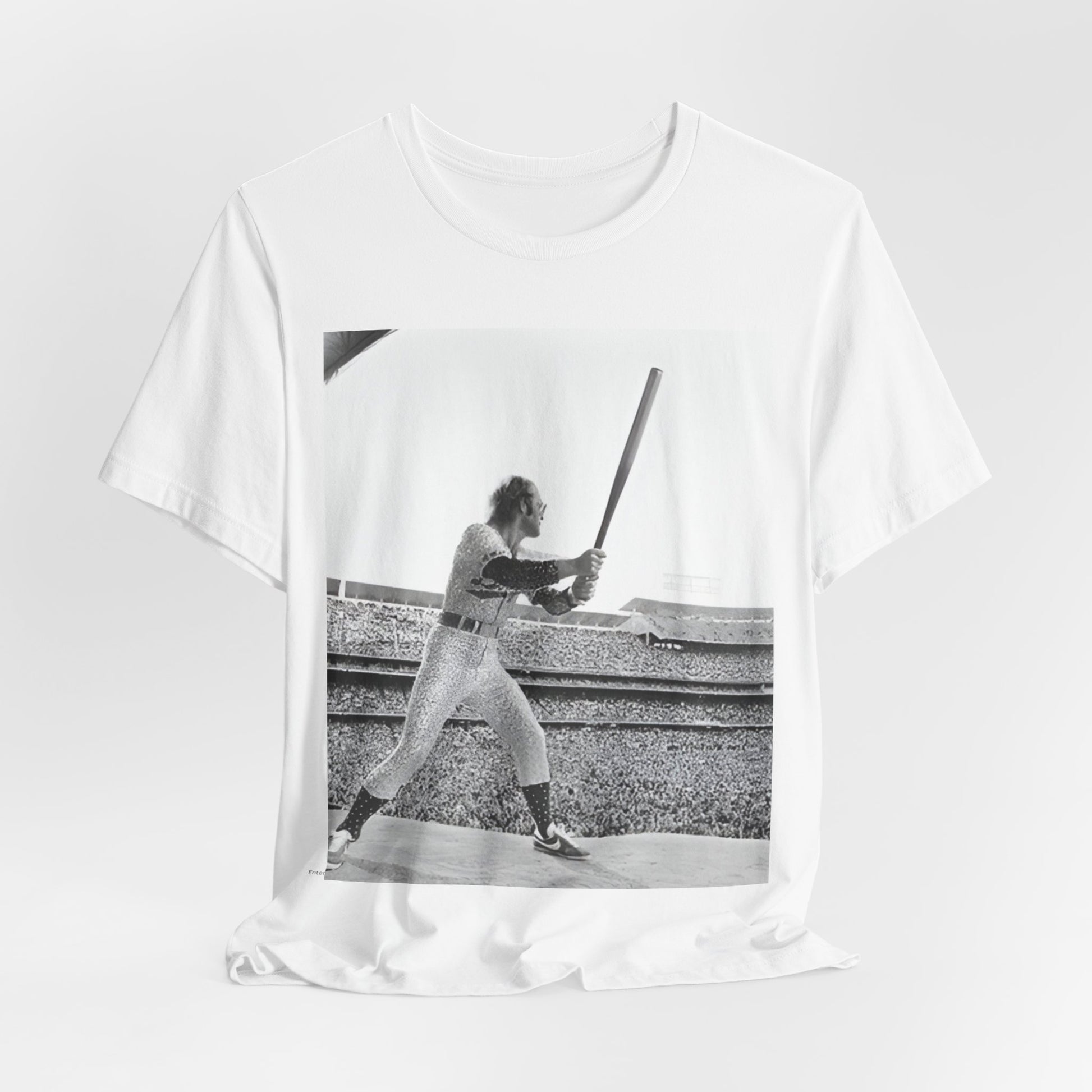 A black graphic t-shirt featuring a black and white graphic or photo related to Elton John's 1975 tour in America.