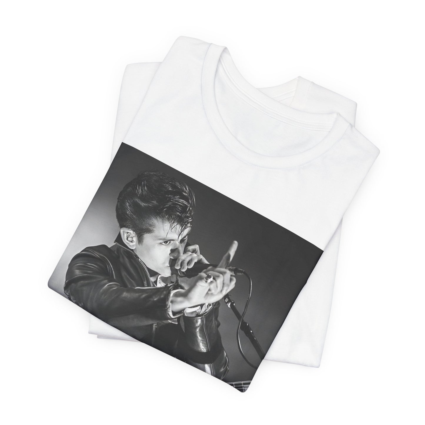 A black graphic t-shirt featuring a dynamic black and white graphic or photo of Arctic Monkeys performing live, emphasizing energy.