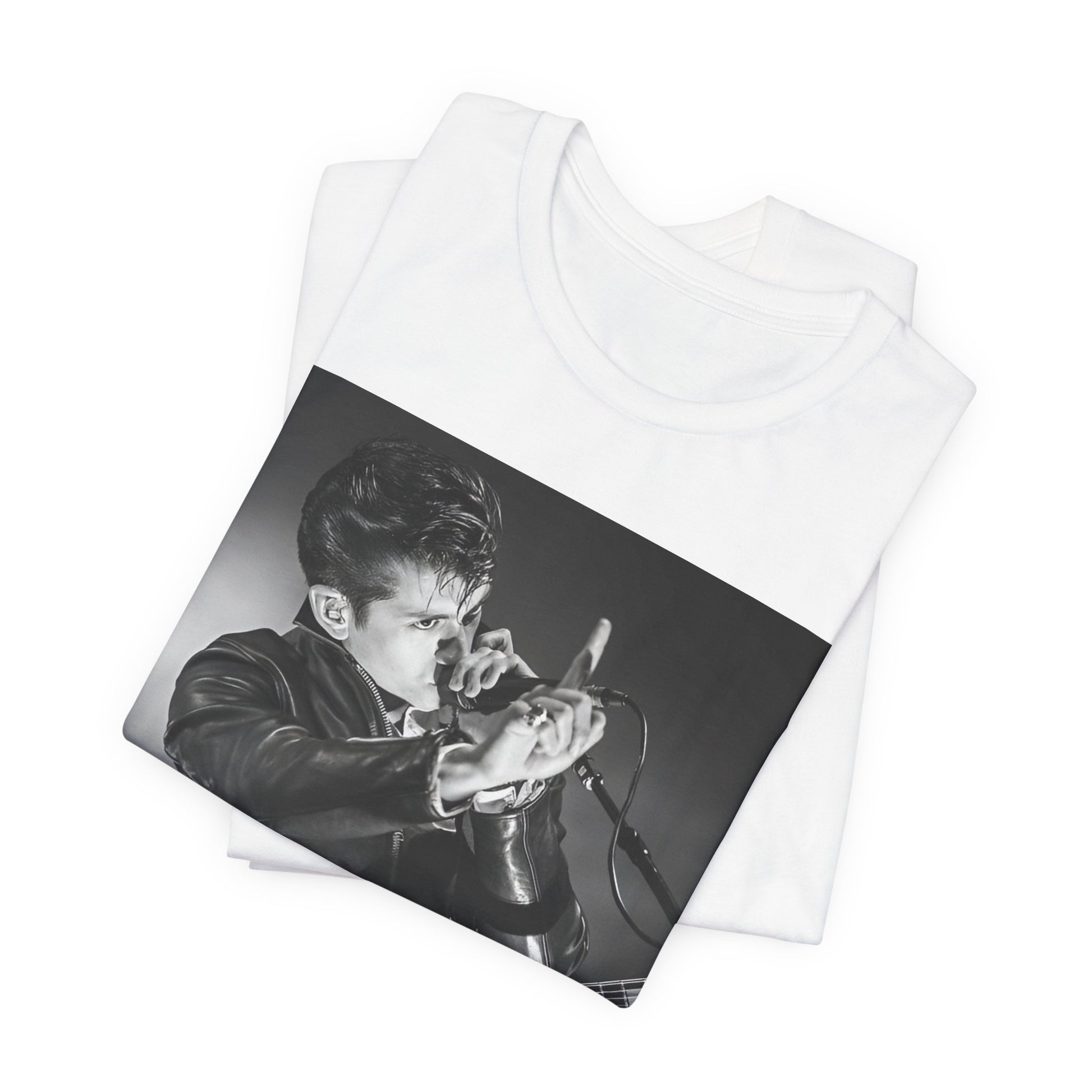 A black graphic t-shirt featuring a dynamic black and white graphic or photo of Arctic Monkeys performing live, emphasizing energy.