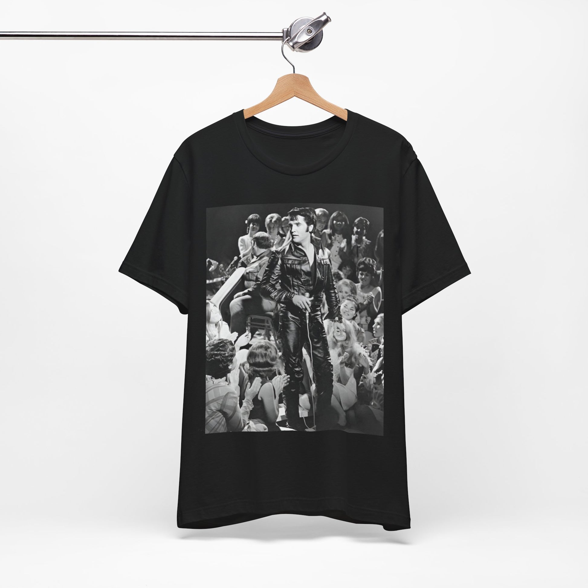 A black graphic t-shirt featuring a vintage black and white photo or graphic of Elvis Presley performing live on stage.