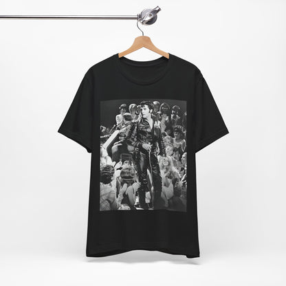 A black graphic t-shirt featuring a vintage black and white photo or graphic of Elvis Presley performing live on stage.