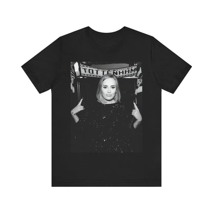 A black graphic t-shirt featuring a photo of Adele in a casual setting, surrounded by fans at a Tottenham event, showing her smiling or interacting.
