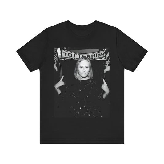 A black graphic t-shirt featuring a photo of Adele in a casual setting, surrounded by fans at a Tottenham event, showing her smiling or interacting.