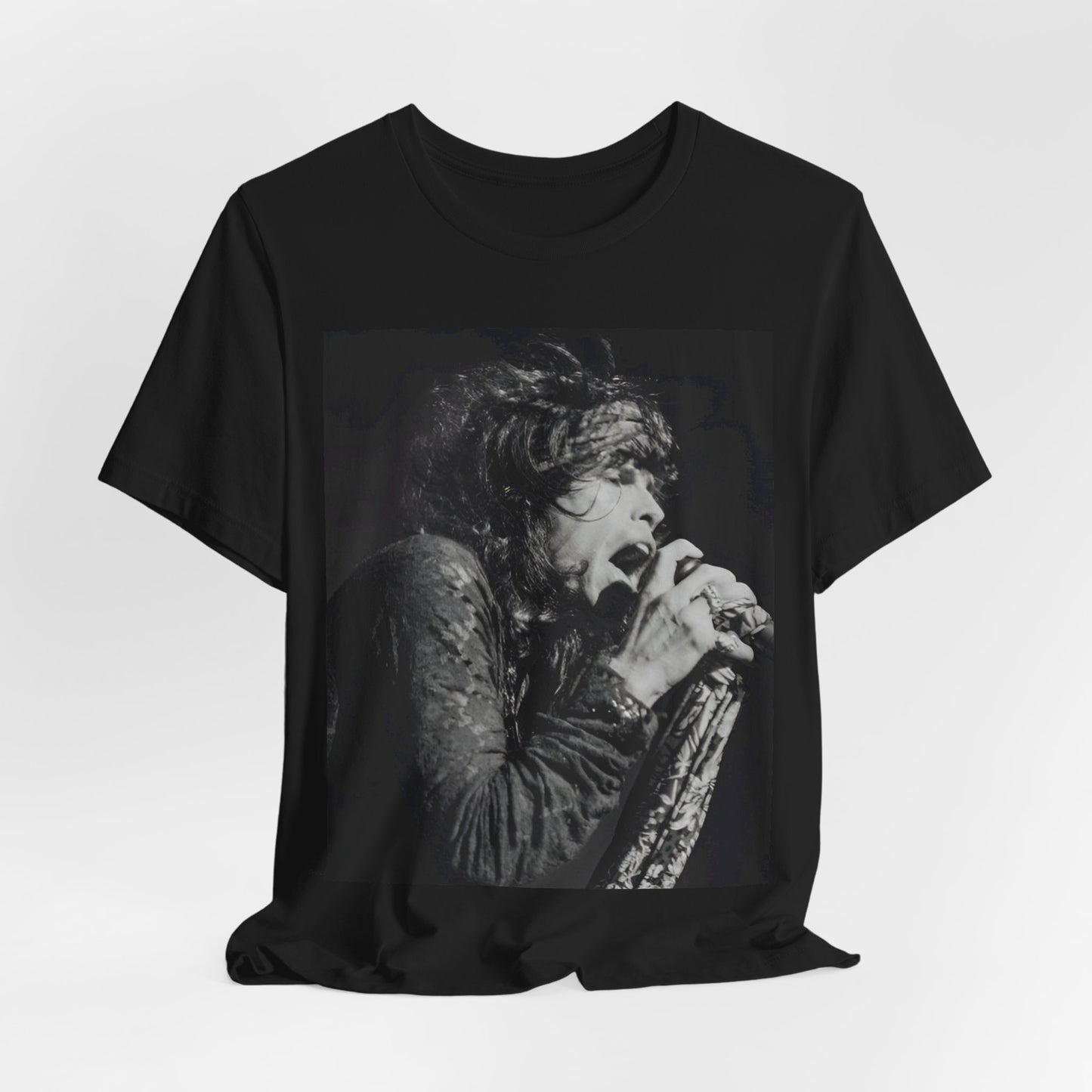 A black graphic t-shirt featuring a retro 70s-style illustration or photo of Aerosmith, designed to evoke their 'On Tour' presence, possibly with band members on stage or tour bus imagery.