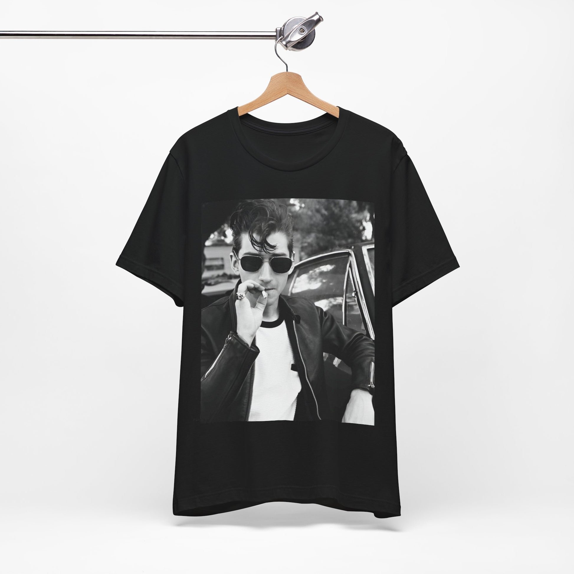 A black graphic t-shirt featuring a classic rock-style graphic of the Arctic Monkeys, possibly with band members in a stylized design.