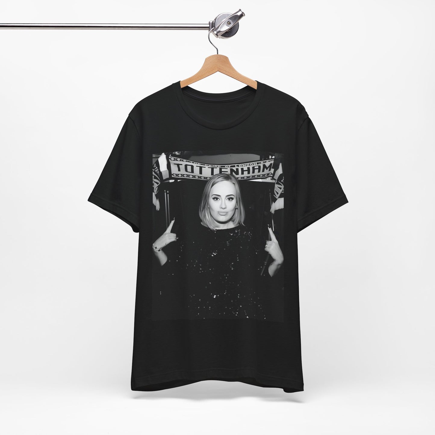 A black graphic t-shirt featuring a photo of Adele in a casual setting, surrounded by fans at a Tottenham event, showing her smiling or interacting.