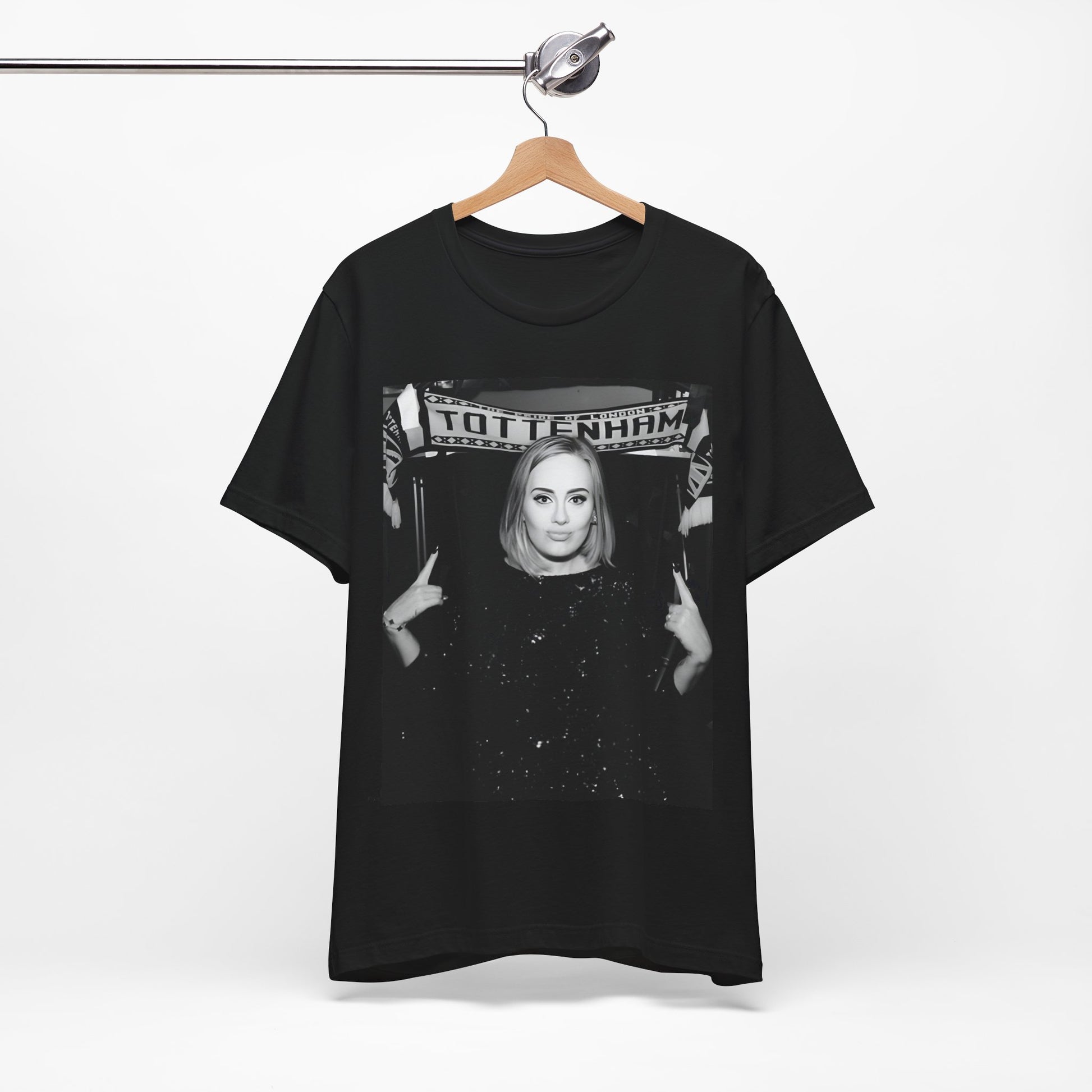 A black graphic t-shirt featuring a photo of Adele in a casual setting, surrounded by fans at a Tottenham event, showing her smiling or interacting.