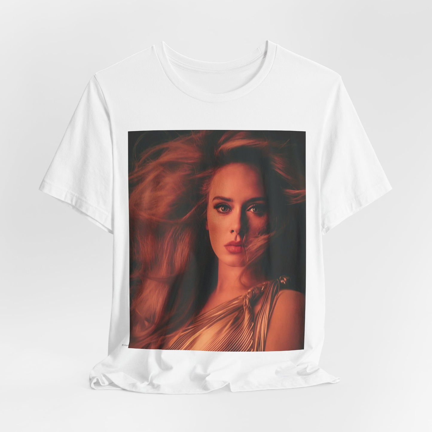 A black graphic t-shirt featuring a glamorous portrait of Adele wearing a golden gown, with voluminous hair, bathed in warm lighting, giving an editorial look.