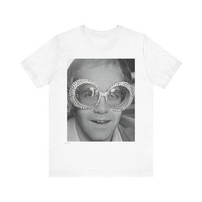 A black graphic t-shirt featuring a graphic of Elton John emphasizing his iconic glasses and fashion.