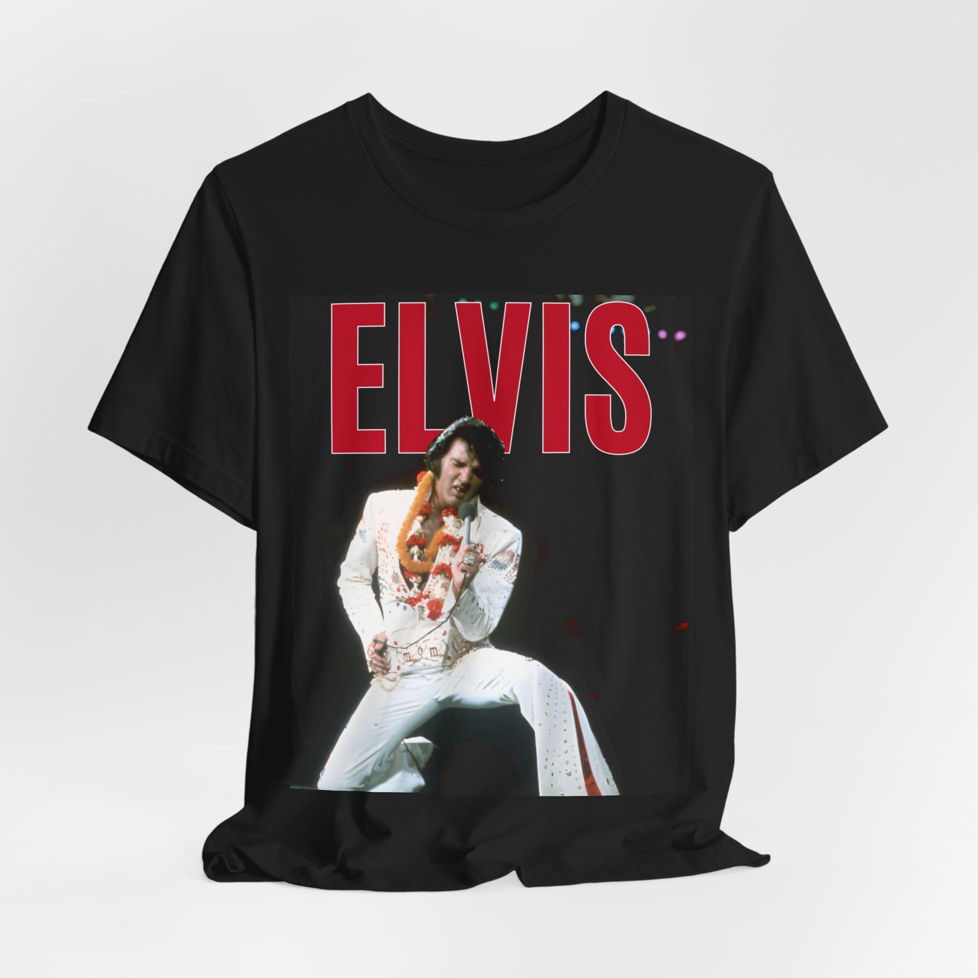 A black graphic t-shirt featuring a glamorous graphic or photo of Elvis Presley on a Las Vegas stage.