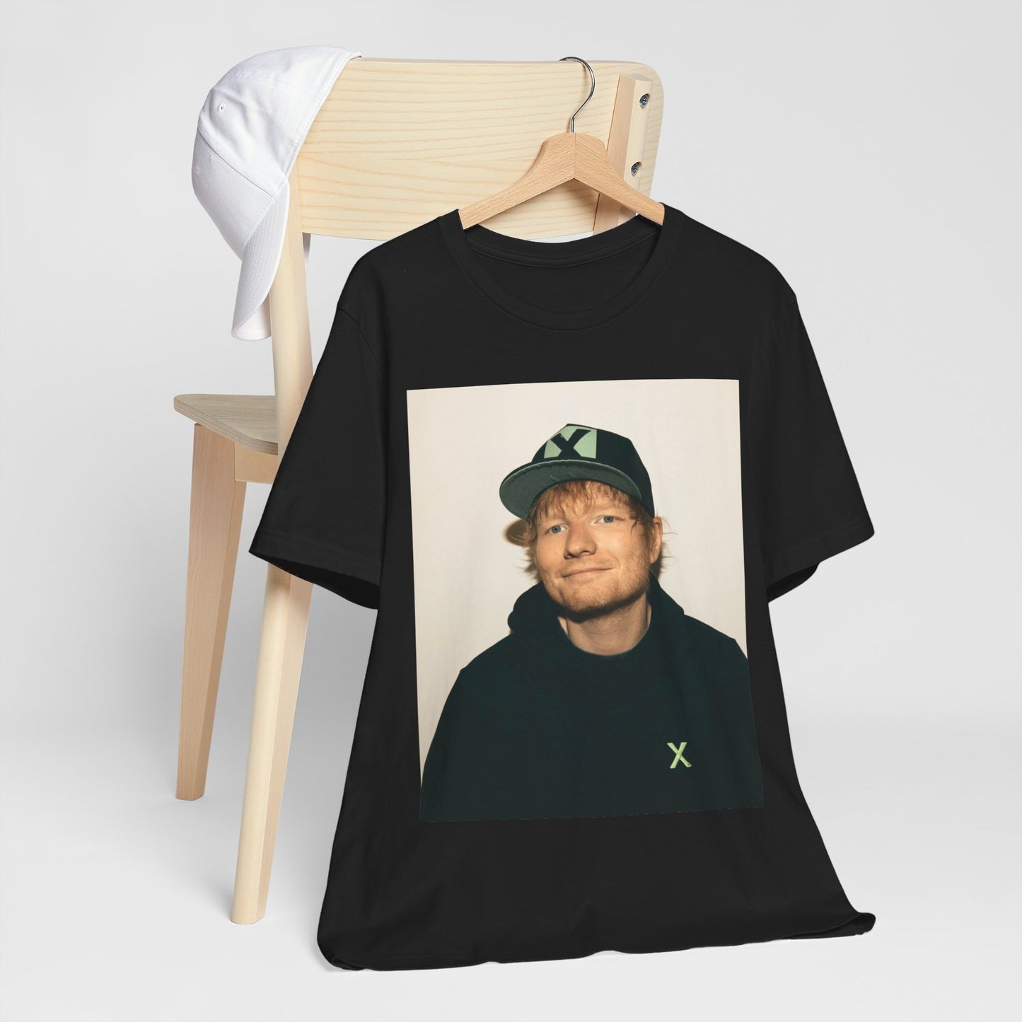 A black graphic t-shirt featuring a glamorous graphic of Ed Sheeran as a global tour icon.