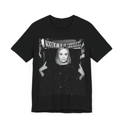 A black graphic t-shirt featuring a photo of Adele in a casual setting, surrounded by fans at a Tottenham event, showing her smiling or interacting.