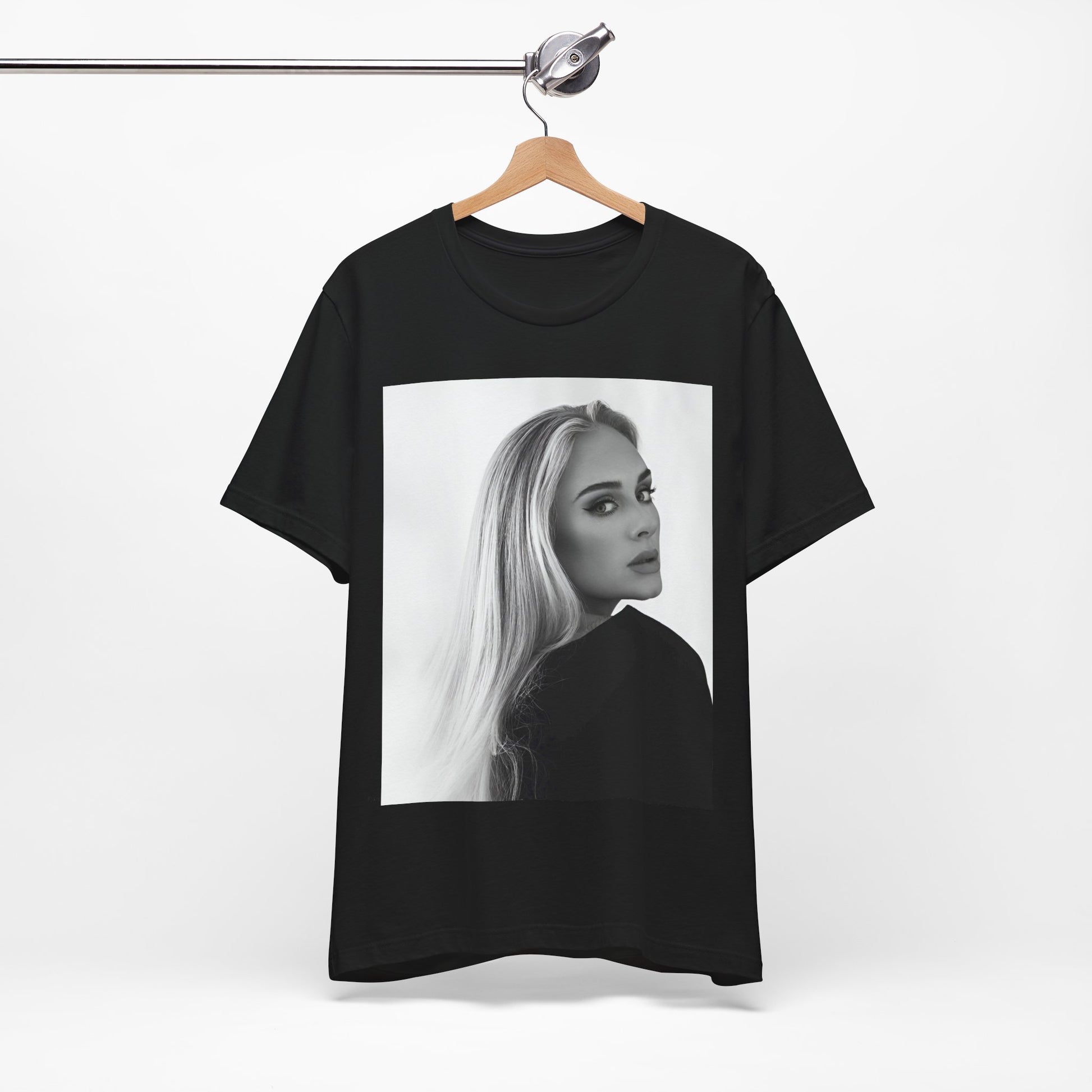 A black graphic t-shirt featuring a black and white, monochromatic portrait of Adele, showing her with a serene or thoughtful expression.