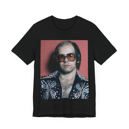 A black graphic t-shirt featuring a vintage glam rock icon graphic of Elton John.