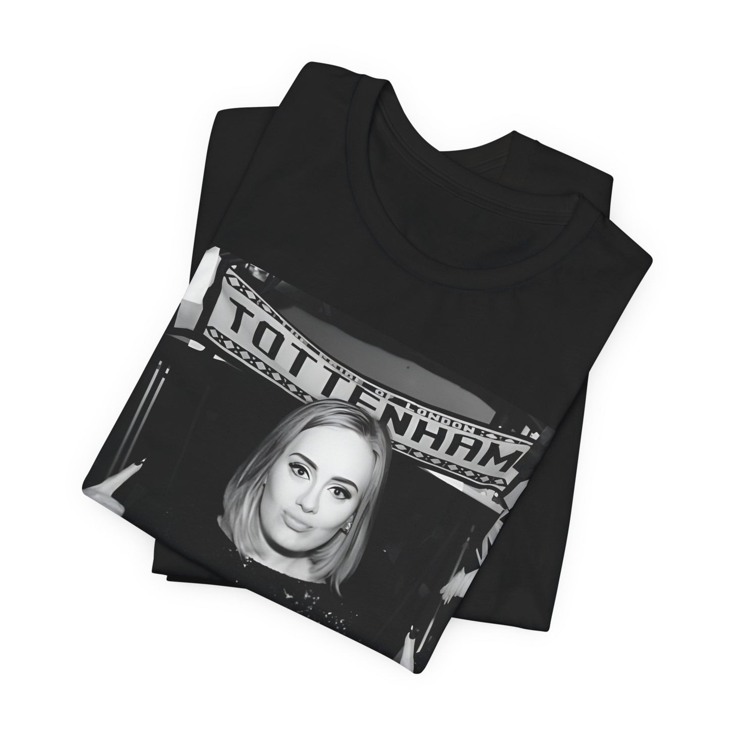 A black graphic t-shirt featuring a photo of Adele in a casual setting, surrounded by fans at a Tottenham event, showing her smiling or interacting.