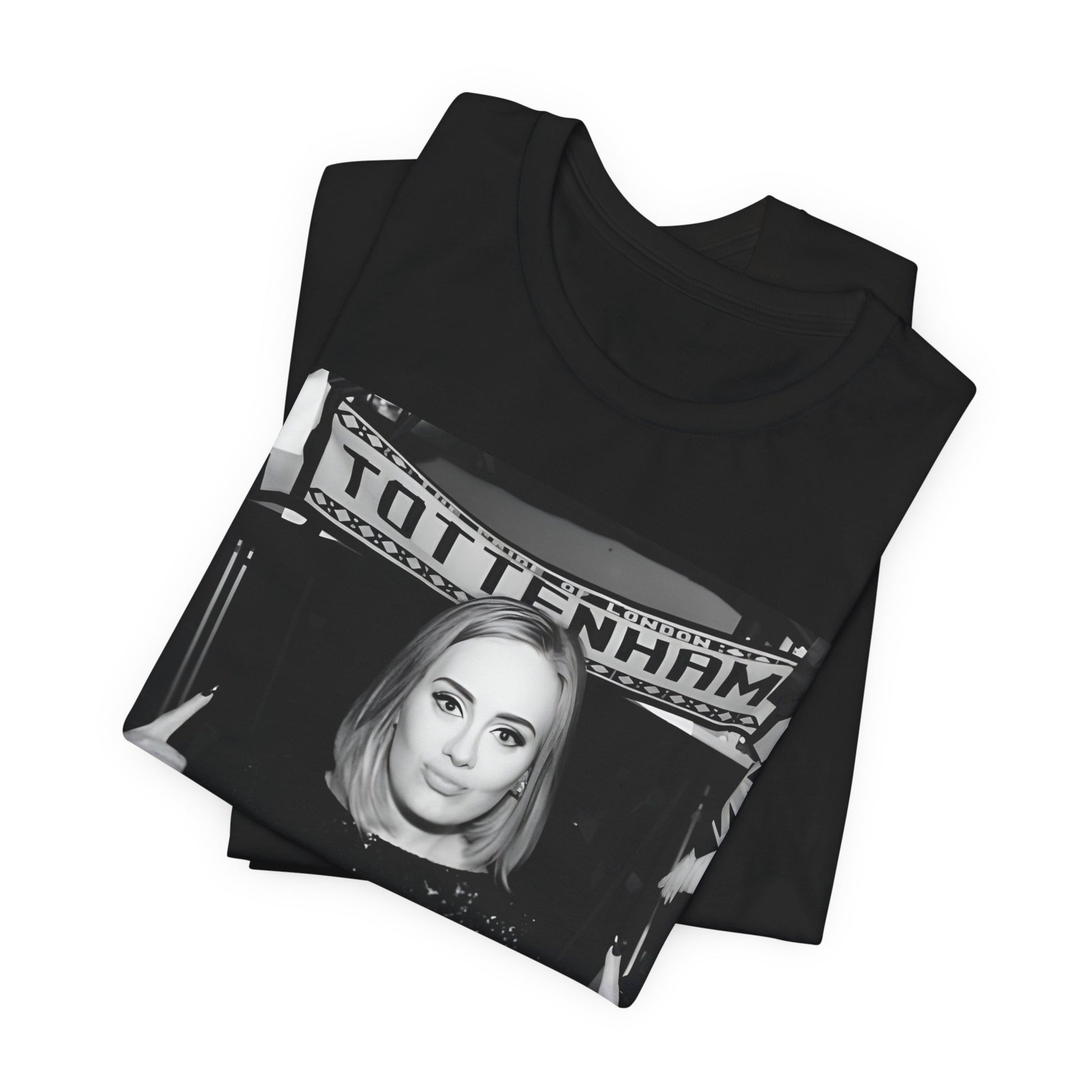 A black graphic t-shirt featuring a photo of Adele in a casual setting, surrounded by fans at a Tottenham event, showing her smiling or interacting.