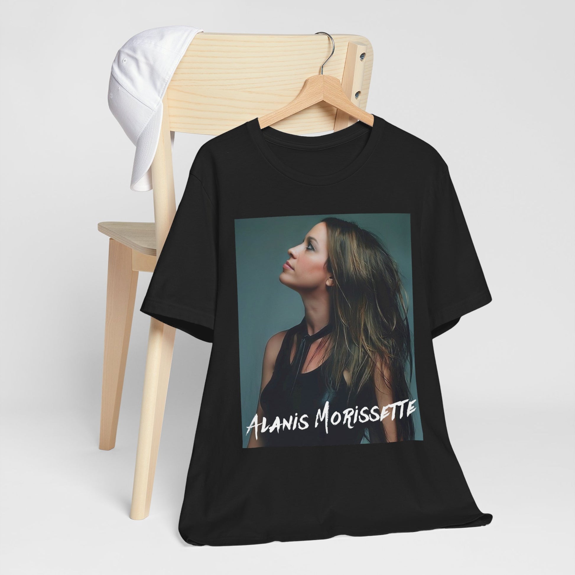 A black graphic t-shirt featuring a retro-style graphic of Alanis Morissette, possibly with her signature or a unique artistic interpretation.