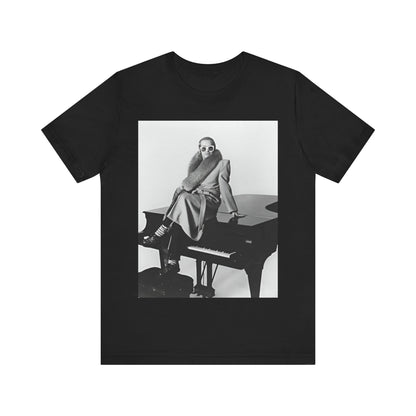 A black graphic t-shirt featuring a black and white photo of Elton John playing the piano.