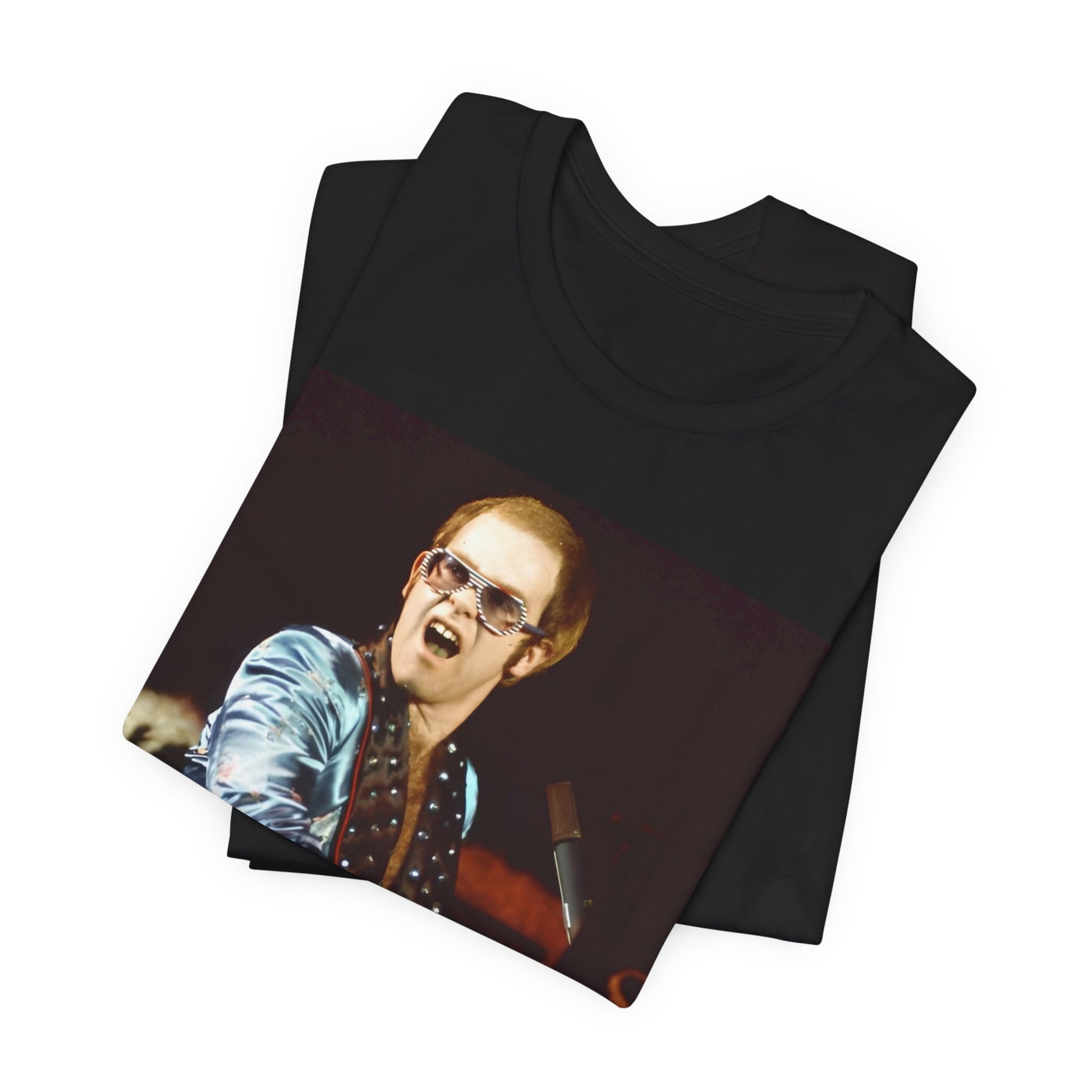 A black graphic t-shirt featuring a retro graphic related to Elton John's 'Rocket Man' song or era.
