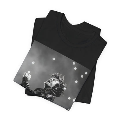 A black graphic t-shirt featuring a glamorous graphic or photo of Harry Styles performing on stage.