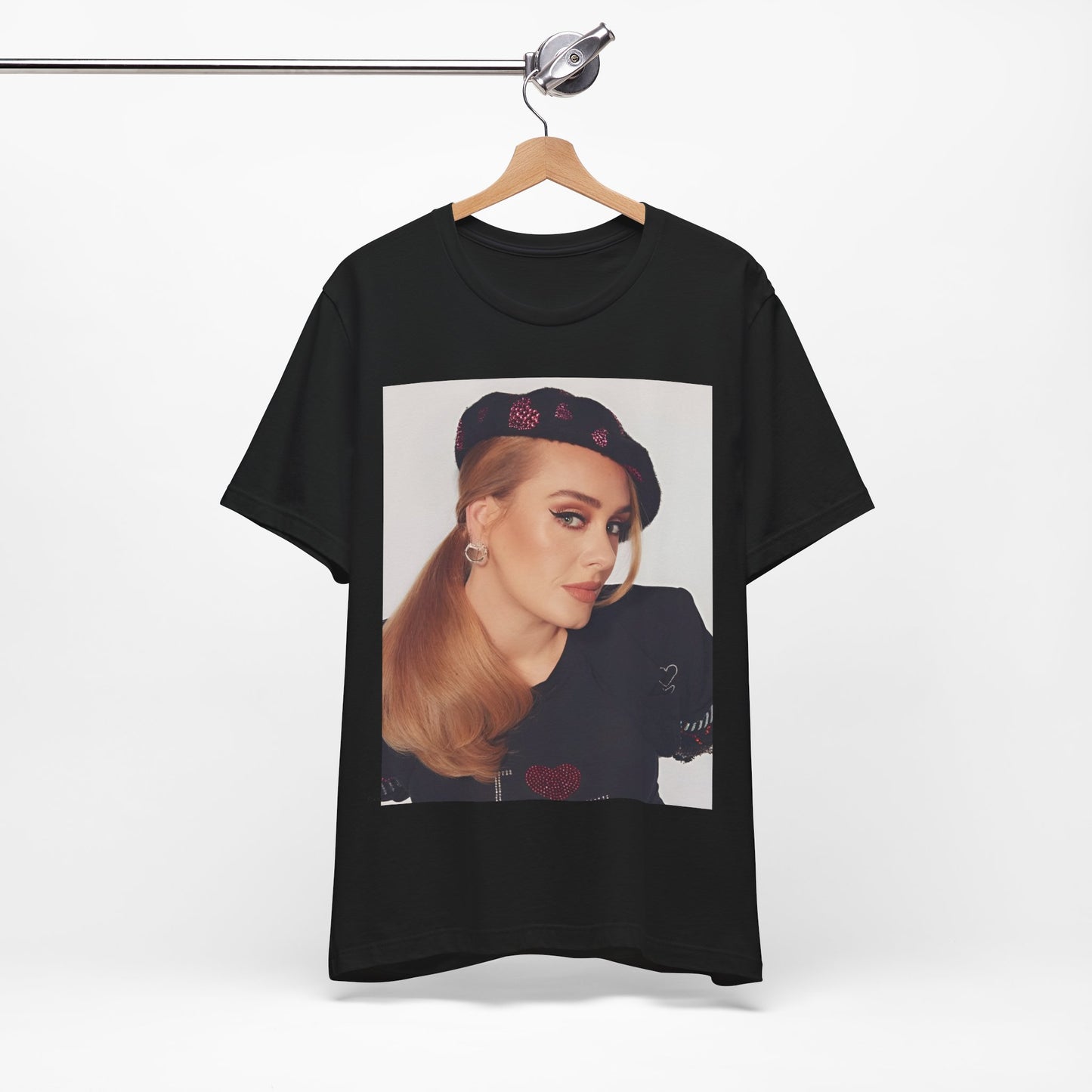 A black graphic t-shirt featuring a black and white photo of Adele wearing a heart-shaped beret, with a gentle or smiling expression.