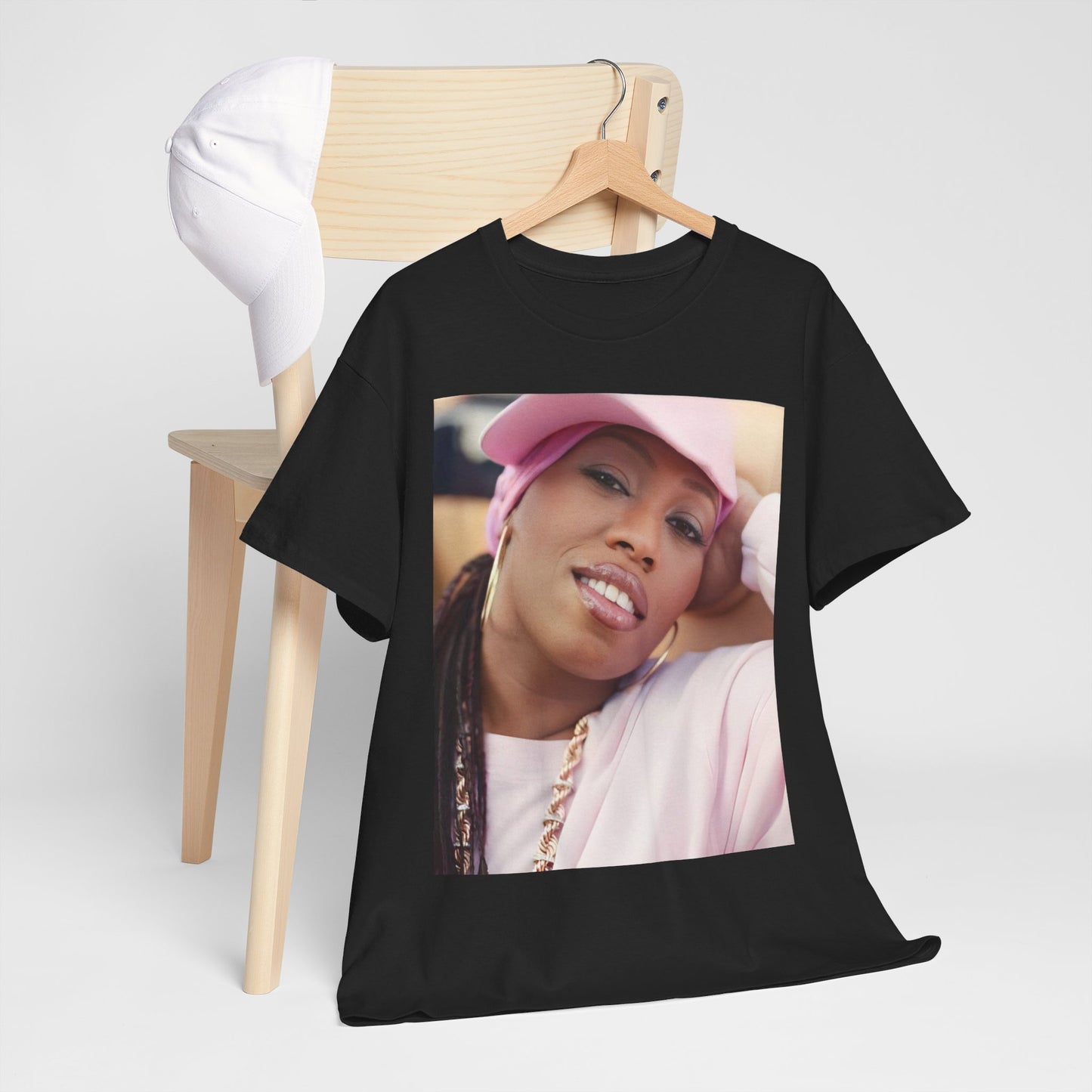 A black graphic t-shirt featuring a 90s rap graphic of Missy Elliott from her early days, emphasizing a raw style.