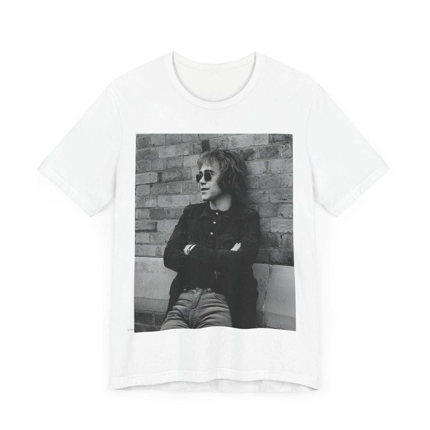 A black graphic t-shirt featuring a vintage graphic related to Elton John's 'Farewell Yellow Brick Road' tour.