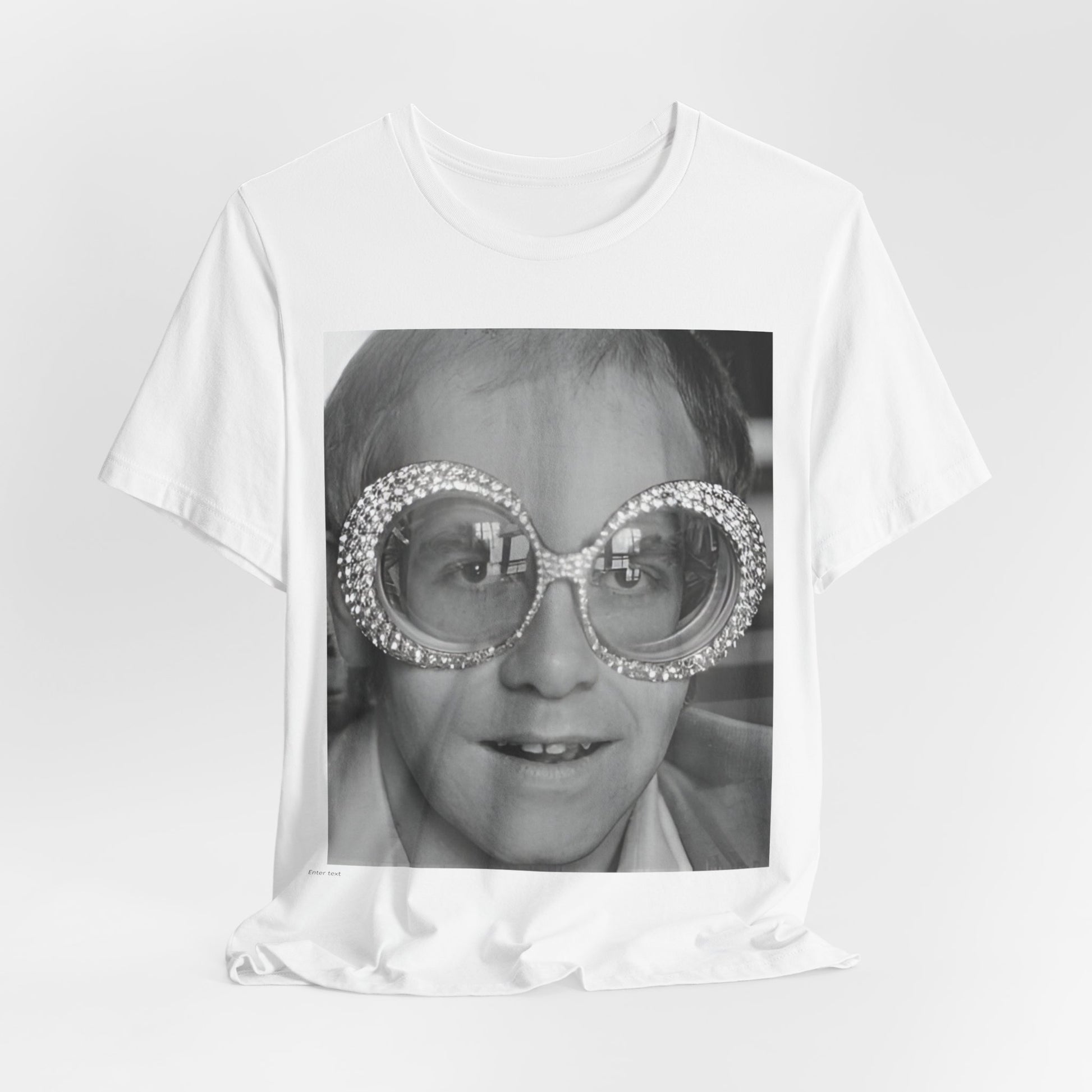 A black graphic t-shirt featuring a graphic of Elton John emphasizing his iconic glasses and fashion.