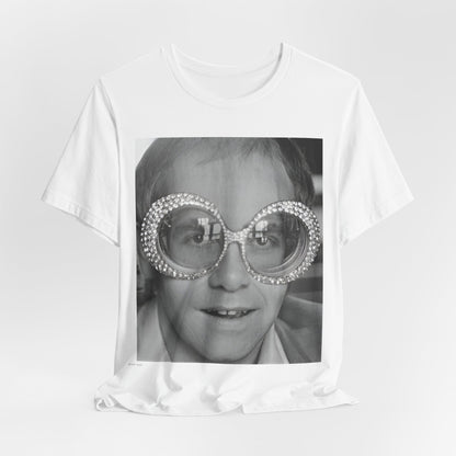A black graphic t-shirt featuring a graphic of Elton John emphasizing his iconic glasses and fashion.