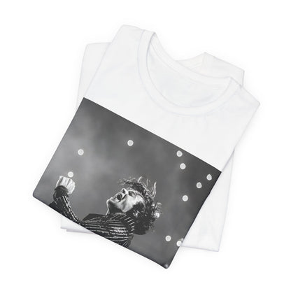 A black graphic t-shirt featuring a glamorous graphic or photo of Harry Styles performing on stage.