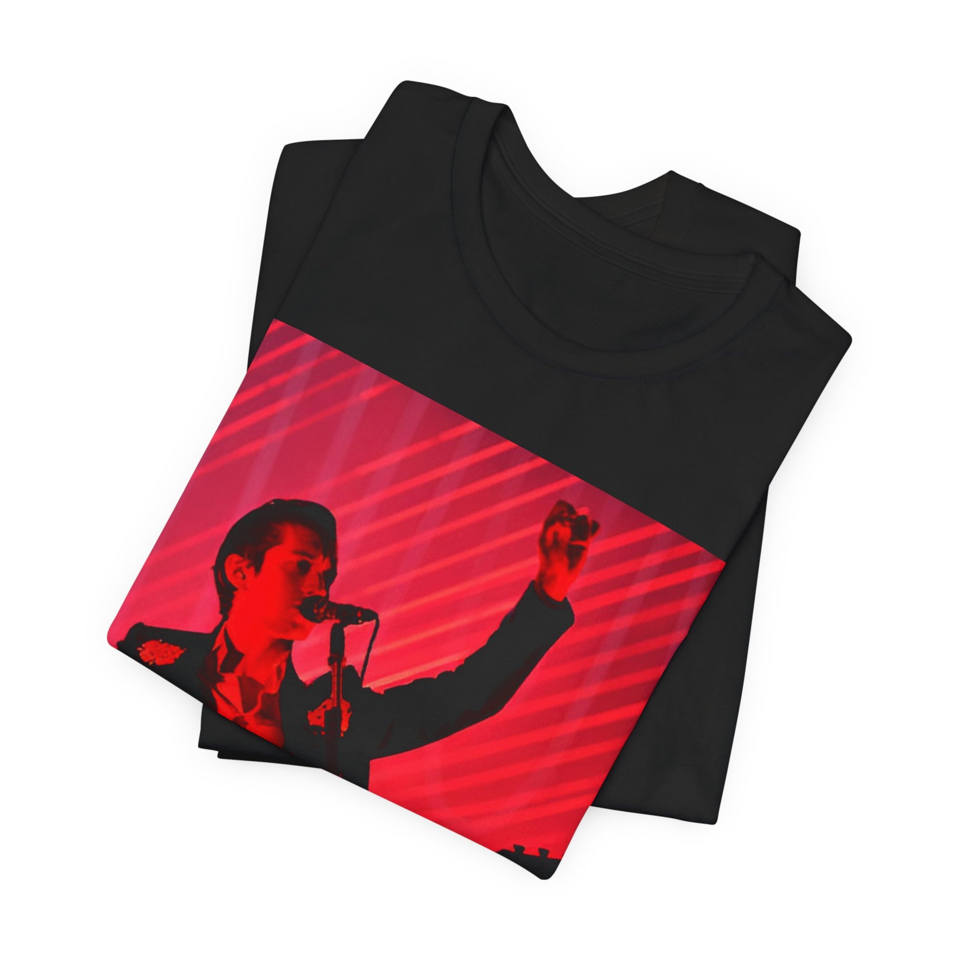 A black graphic t-shirt featuring a dynamic graphic or photo of Arctic Monkeys performing live in concert.