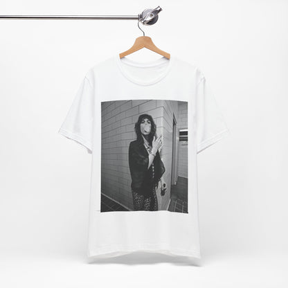 A black graphic t-shirt featuring a retro 70s photo of Aerosmith band members in a backstage setting, showing a candid moment.