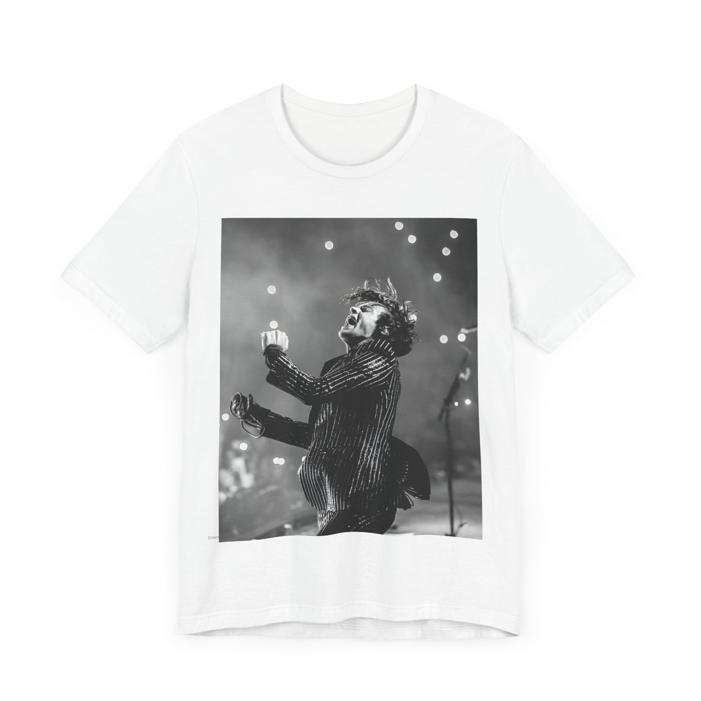 A black graphic t-shirt featuring a glamorous graphic or photo of Harry Styles performing on stage.