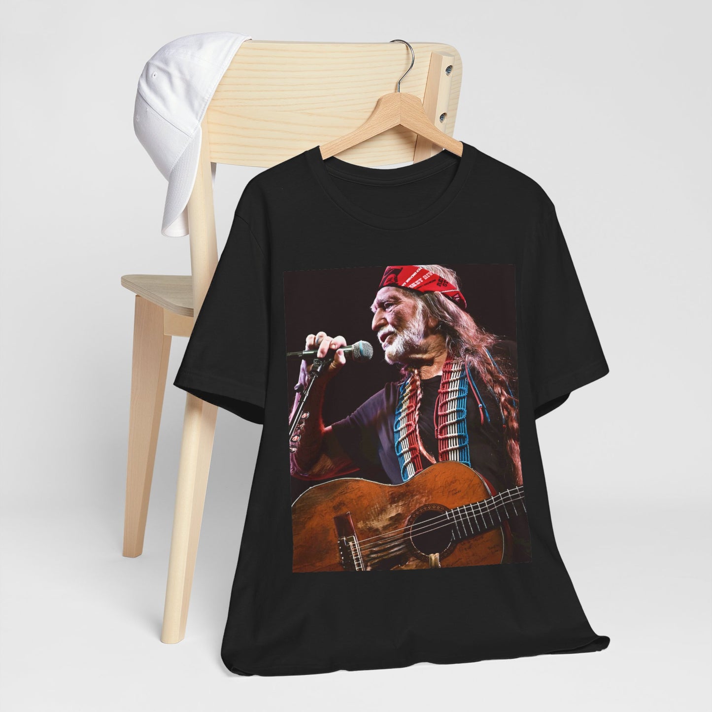 A black graphic t-shirt featuring a graphic of Willie Nelson with his iconic long hair and bandana.
