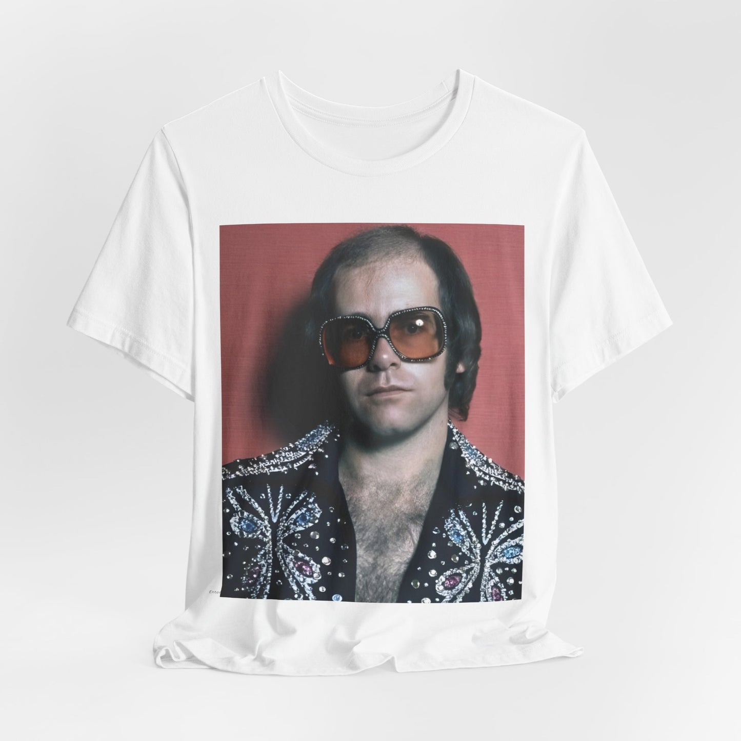 A black graphic t-shirt featuring a vintage glam rock icon graphic of Elton John.