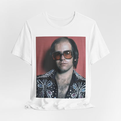 A black graphic t-shirt featuring a vintage glam rock icon graphic of Elton John.